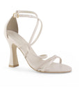 vista diagonal de zapatillas beige con tiras cruzadas de charol tacón medio 10 cm para dama