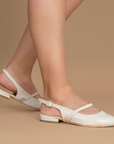 Zapatillas beige destalonadas de charol con tiras cruzadas y hebilla ajustable de piso para dama