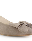 Vista a detalle de punta fina con moño en flats beige para mujer con diseño destalonado y correa ajustable