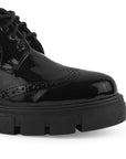 Detalle del material charol en el mocasín negro para dama con cordones funcionales y suela dentada tipo track