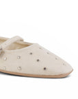 detalle del material durazno en balerinas beige con pulsera ajustable y estoperoles