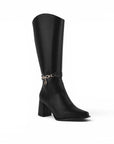 Vista diagonal de la bota negra con punta fina, cadena decorativa, cremallera y tacón medio 9cm para dama