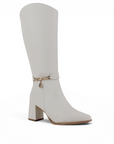 Vista diagonal de la bota beige con punta fina, cadena decorativa, cremallera y tacón medio 9cm para dama