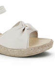 Detalle del material sintético en sandalia beige para dama con pulsera ajustable al tobillo plataforma media 5cm y punta abierta