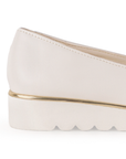 Vista del detalle metálico en la plataforma baja 3cm del mocasín beige para dama con herraje decorativo