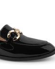 Detalle del material charol en mocasín negro con suela de piso y herraje metálico decorativo para dama