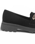 Vista trasera del tacón bajo 3cm con suela chunky tipo track del mocasín negro para dama con herraje metálico decorativo
