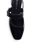 Vista de material charol en zapatilla negra para mujer con punta cerrada y hebilla ajustable