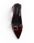 Vista superior de zapatilla vino destalonada de charol con punta fina, detalles metálicos y tacón medio 7cm para dama