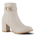 vista diagonal de botas beige para dama con detalle en hebilla oro y tacón