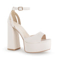 Vista diagonal de zapatilla para mujer con pulsera y tacón alto 13cm en color beige