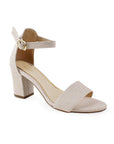 Vista diagonal de zapatilla beige para mujer con pulsera y tacón bajo