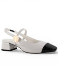 vista diagonal de zapatillas beige con negro para mujer pulsera y tacón cuadrado