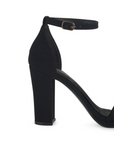 Vista trasera de zapatilla para mujer color negro acabado buck con pulsera y tacón medio de 10cm