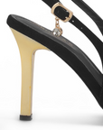 vista trasera del tacón oro de 10 cm en zapatillas negras de dama