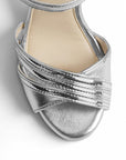 vista del detalle frontal de las zapatillas plata con pulsera y plataforma de dama