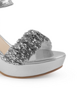 Vista a detalle de tira ancha brillosa en zapatilla plata para mujer con pulsera y tacón ancho 10cm