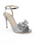 vista diagonal de zapatilla plata de mujer con moño y tacon