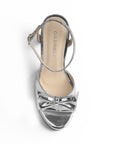 vista superior de zapatilla plata de mujer con moño y tacon
