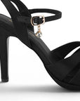 Vista trasera de zapatillas negras para mujer con tacón medio y tiras