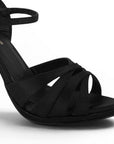 Detalle de material shantung en zapatillas negras con tacón y tiras