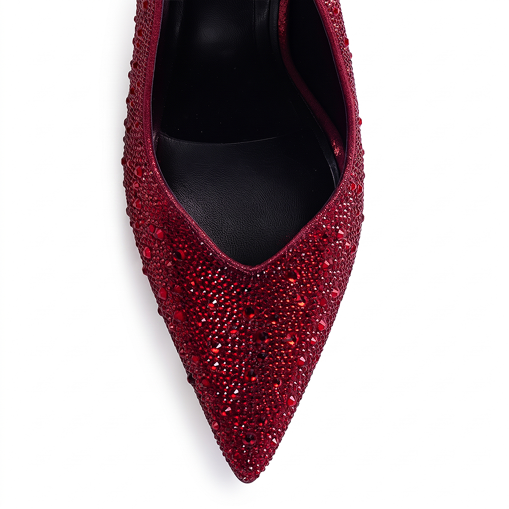Vista del detalle en la punta fina con pedrería brillante de la zapatilla roja tipo stiletto para dama con tacón medio 10 cm 