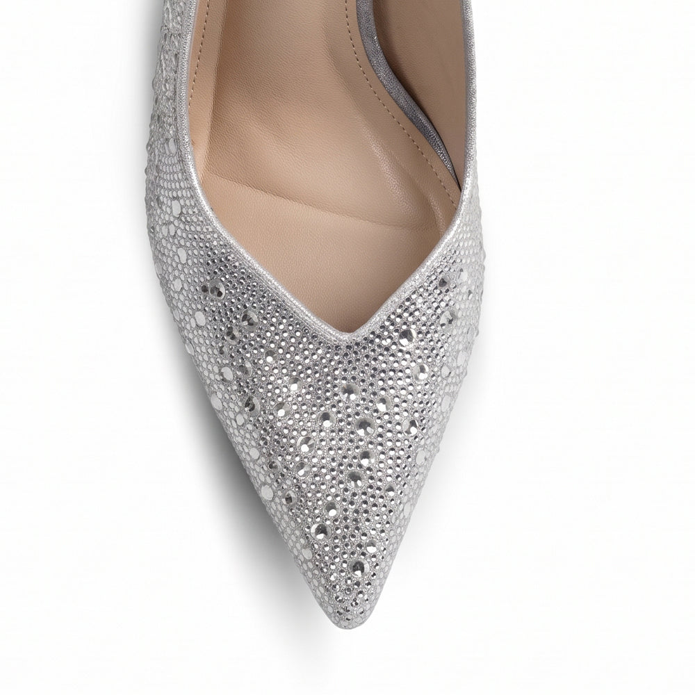 Vista del detalle en la punta fina con pedrería brillante de la zapatilla plateada tipo stiletto para dama con tacón medio 10 cm 