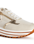 Detalle del material sintetico en tenis beige para dama con suela antiderrapante y detalles metalicos 

