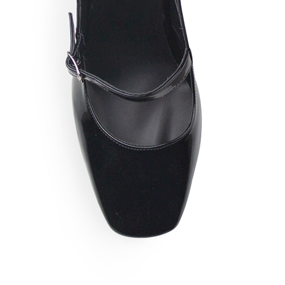 vista del detalle en correa ajustable de las zapatillas negras de charol  para dama destalonadas con tacón medio 8cm 