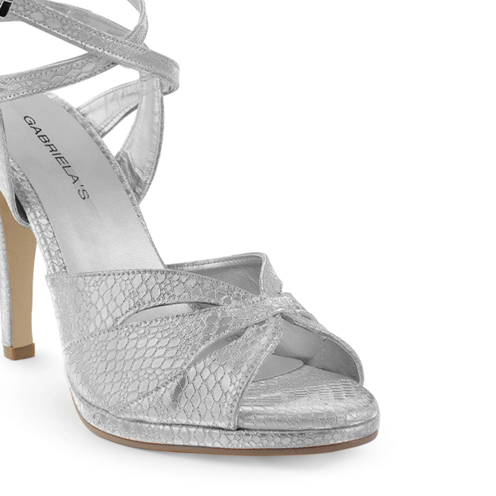 Vista a detalle de zapatilla para mujer con pulsera ajustable al tobillo y tacón delgado de 11cm color plata