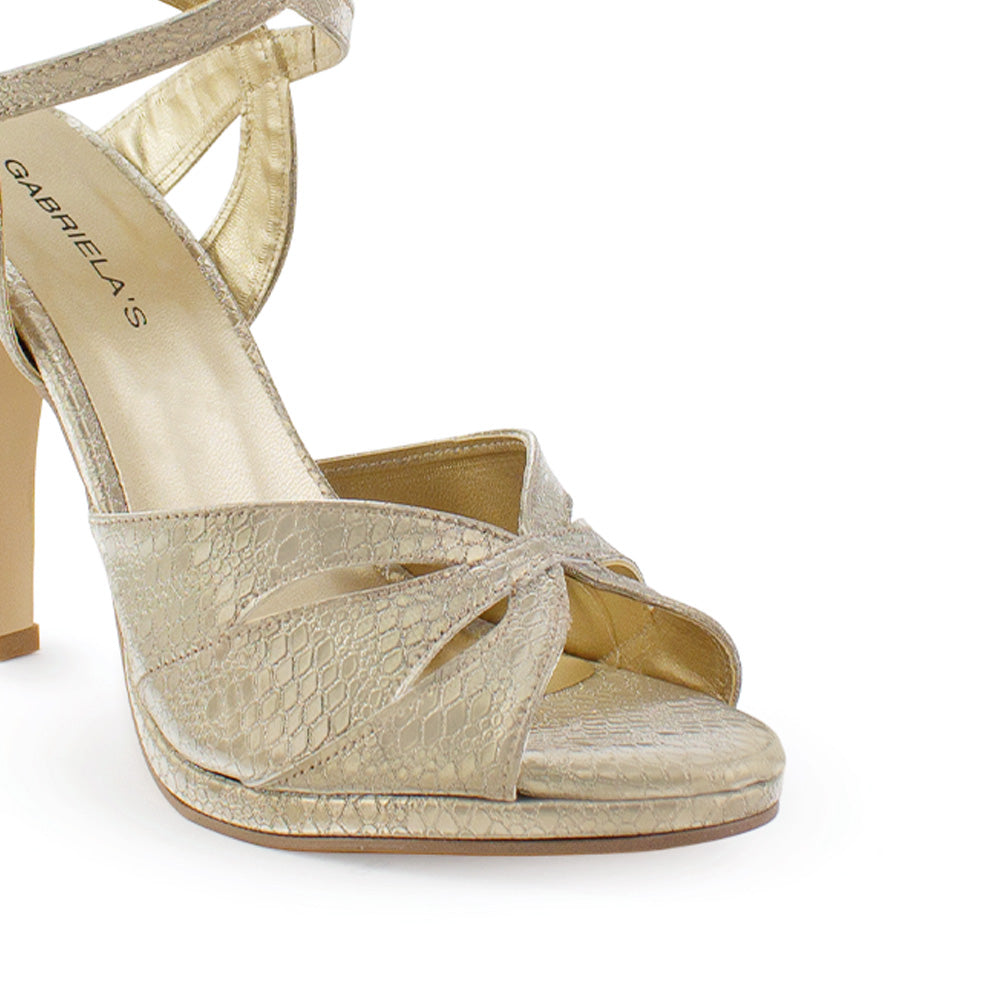 Vista a detalle de zapatilla para mujer con pulsera ajustable al tobillo y tacón delgado de 11cm color oro