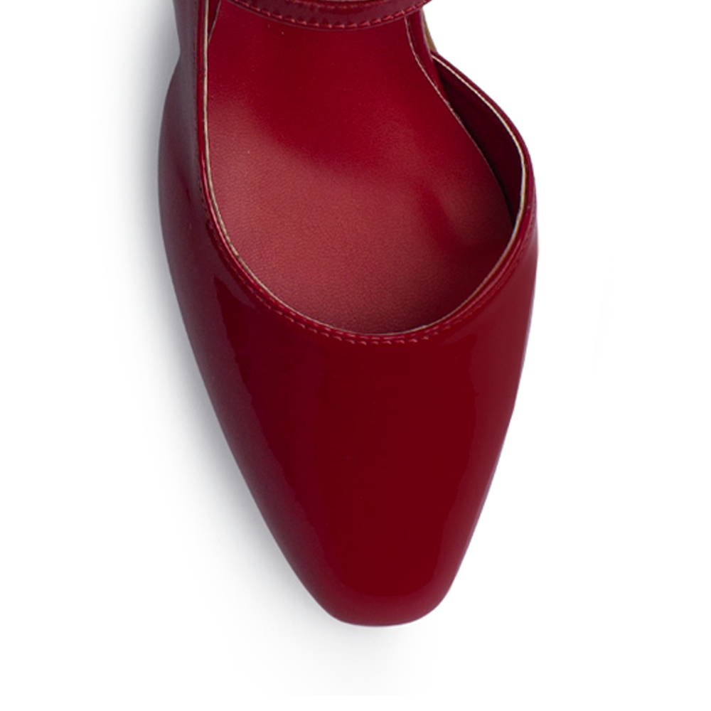 Vista de material charol en zapatilla roja destalonada para mujer con punta cerrada pulsera ajustable y tacón bajo de 4cm