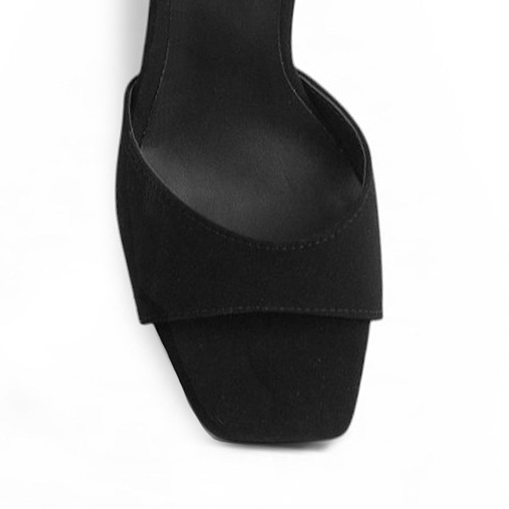 Vista de material buck en zapatilla negra para mujer de diseño descubierto con punta cuadrada pulsera ajustable al tobillo y tacón medio de 9cm