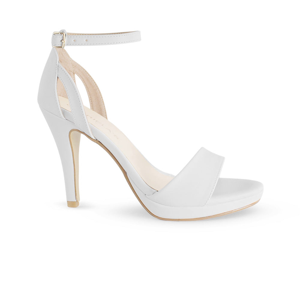 vista lateral de zapatillas blancas de dama con plataforma pulsera ajustable al tobillo y tacón medio 8cm 