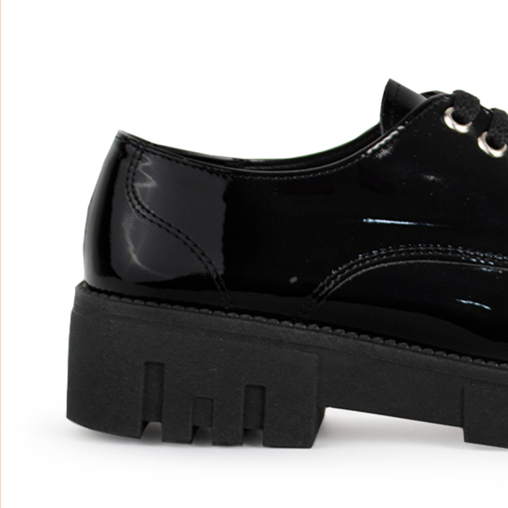 Vista trasera de tacón bajo ancho de 4cm en mocasín negro para mujer con agujetas y suela truck