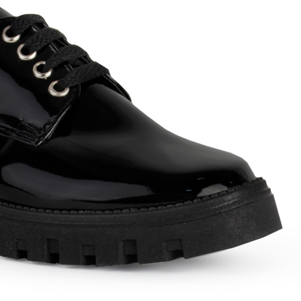 Vista de punta en mocasín negro para mujer con suela chunky tipo truck, agujetas y tacón ancho bajo de 4cm