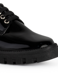 Vista de punta en mocasín negro para mujer con suela chunky tipo truck, agujetas y tacón ancho bajo de 4cm