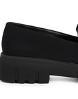 Vista trasera de tacón ancho bajo de 4cm en mocasín negro de meter para mujer con tira frontal tipo antifaz 