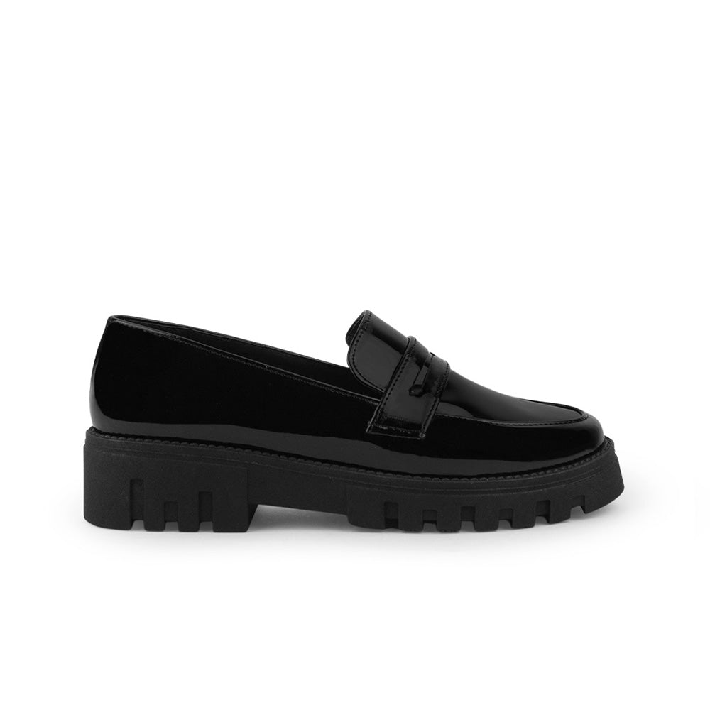 Vista lateral del mocasín negro para dama con suela tipo chunky y antifaz decorativo al frente 