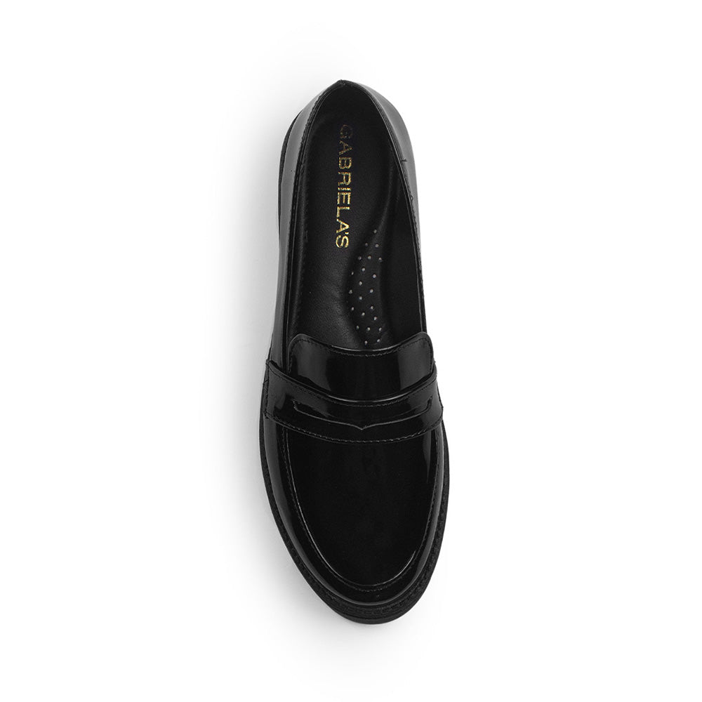 Vista superior del mocasín negro con punta redonda de charol y antifaz decorativo al empeine para dama 
