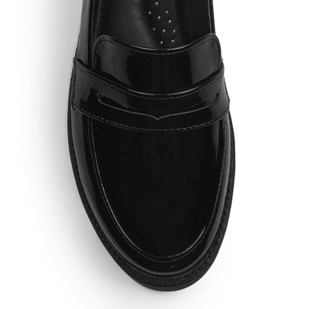 Vista del detalle en el antifaz decorativo del mocasín negro para dama con punta redonda y tacón bajo 4cm 