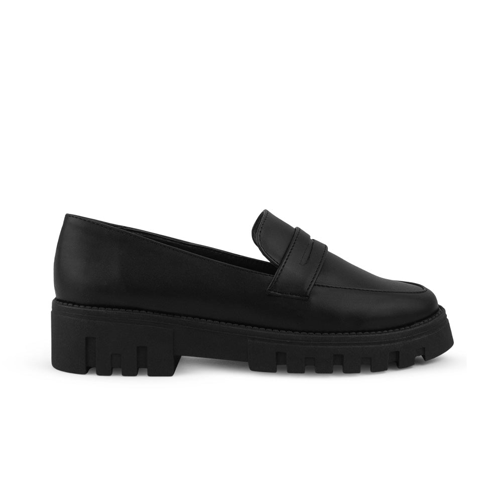 Vista lateral del mocasín negro para dama con suela tipo chunky y antifaz decorativo al frente 