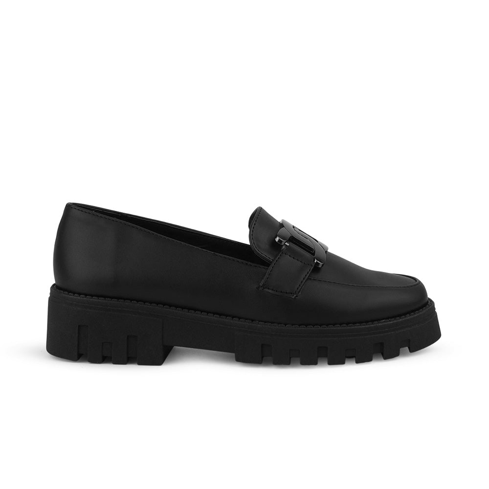 Vista lateral en el mocasín negro con punta redonda, suela tipo chunky y herraje decorativo para dama 
