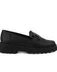 Vista lateral en el mocasín negro con punta redonda, suela tipo chunky y herraje decorativo para dama 
