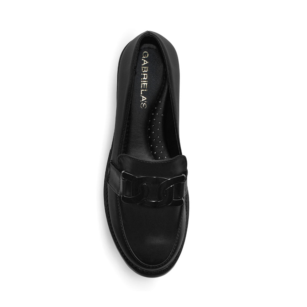 Vista superior del mocasín negro para dama con punta redonda, herraje metálico decorativo y tacón bajo 4cm 