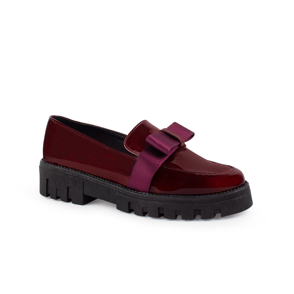 Vista diagonal del mocasín vino de charol con plataforma tipo chunky, moño decorativo y punta redonda para dama