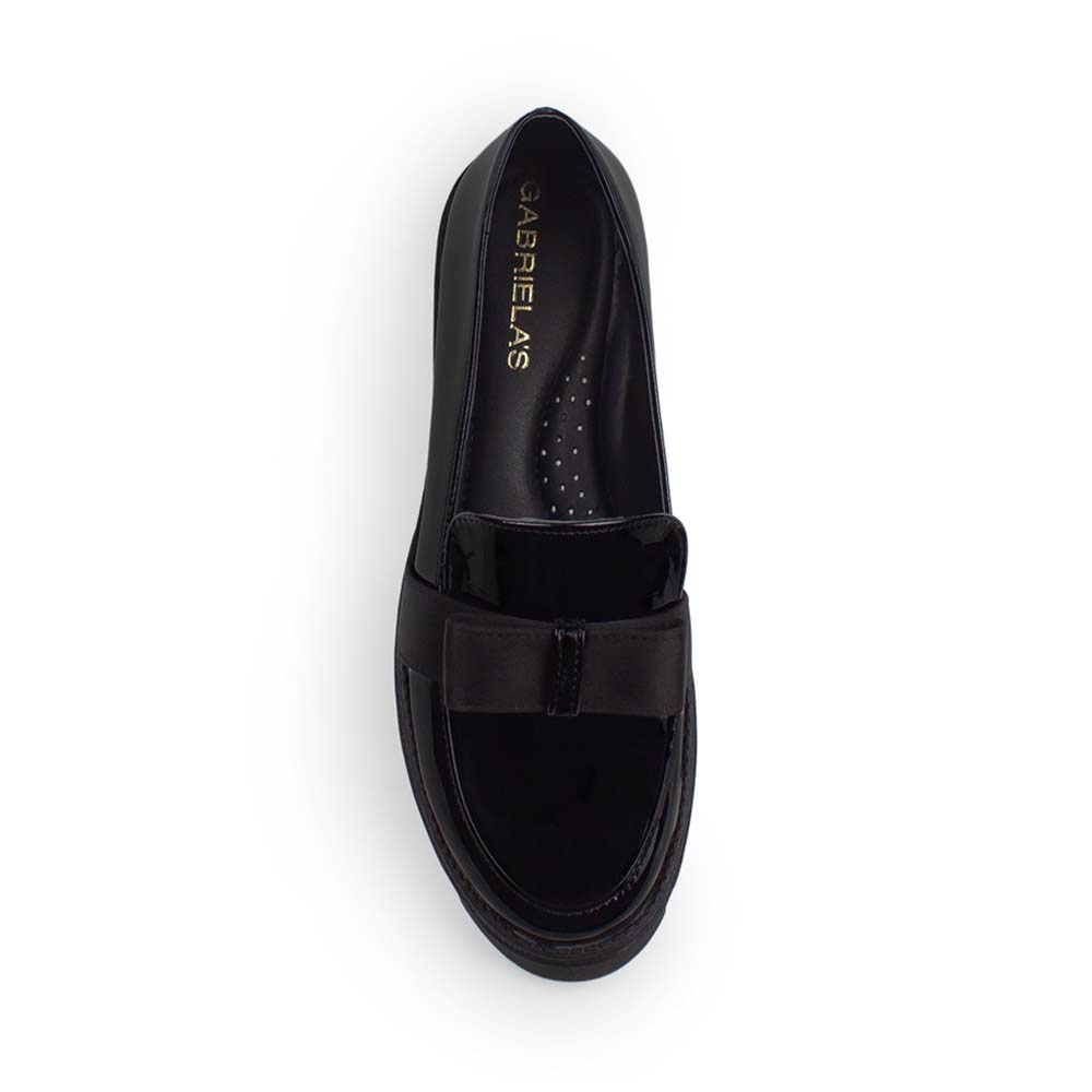 Vista superior del mocasín negro de charol con punta redonda y moño decorativo para dama 