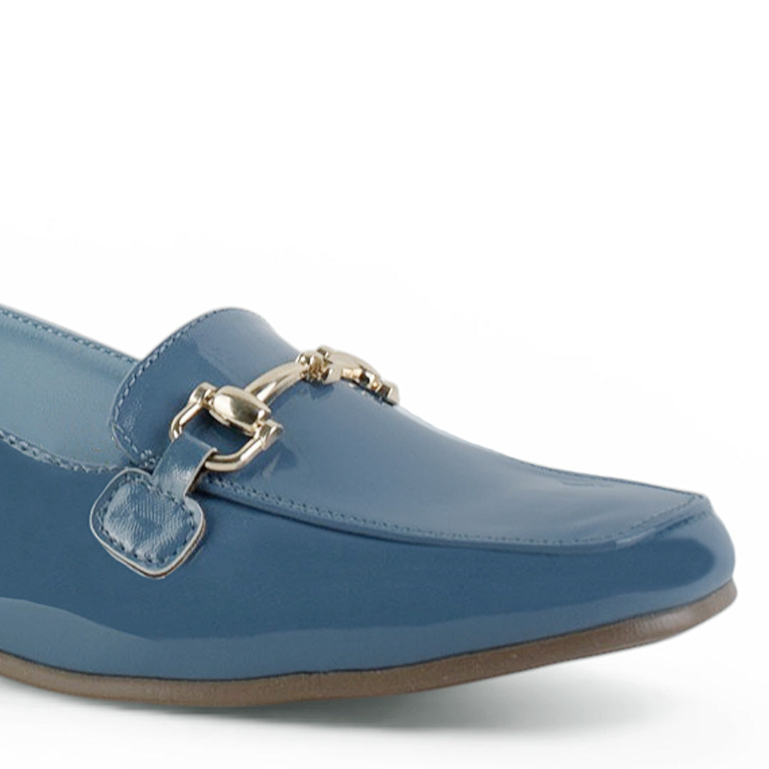 Detalle del material charol en flat azul para dama de piso con detalles metálicos y pulsera ajustable  