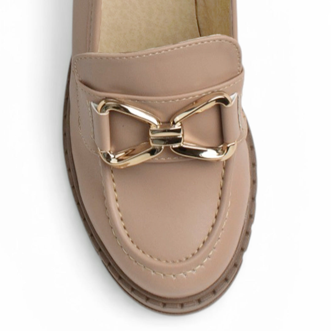 Vista del detalle en herraje decorativo del mocasín nude para dama con punta redonda y plataforma chunky tipo track