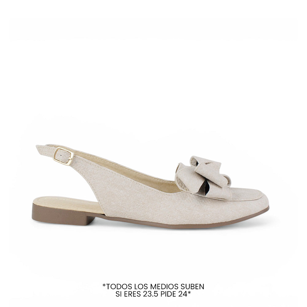 Vista lateral de flat beige para dama de piso con pulsera ajustable y moño en el empeine